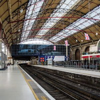 ロンドンのユーストン駅プラットホームの赤と黒の鉄骨アーチ天井の写真