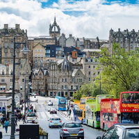 観光バスが停車するエディンバラの歴史的街並みの写真