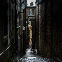 雨で濡れた細い路地を照らすランプ（エディンバラ）の写真