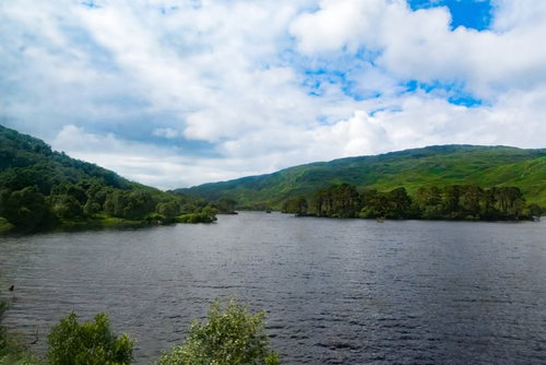 湖畔の緑の山々に囲まれた湖、青空と白い雲が映える景勝地