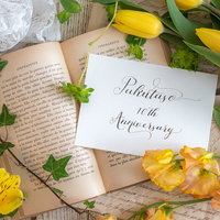 洋書とメッセージカード、黄色いバラで飾ったお祝いの装飾の写真