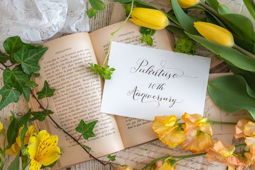 洋書とメッセージカード、黄色いバラで飾ったお祝いの装飾