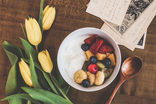 机の上に並んだヨーグルトフルーツ添えとスプーン