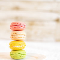 白いお皿に積み重ねられた一番上がピンクのマカロンの写真