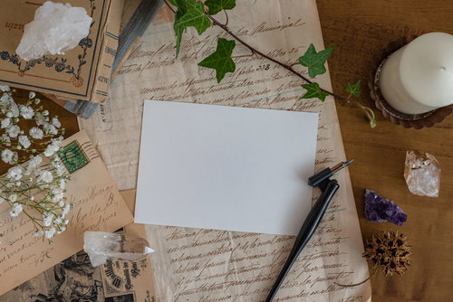 木製テーブルに置かれた書き出す前の真っ白なハガキ