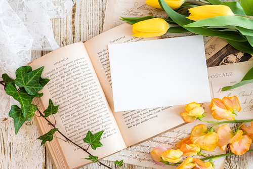 洋書の上にある真っ白な手紙と黄色いチューリップ