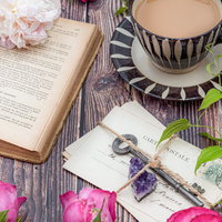 生花香る古書とティーカップ、手紙のテーブルの写真
