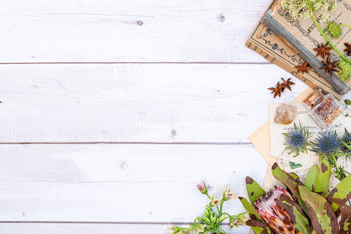 木目の天板に古書と手紙、生花を配置した雑貨