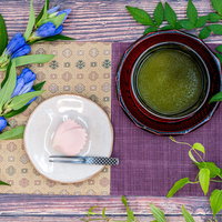 白い練り切りと緑茶を合わせた花飾りのお茶時間の写真