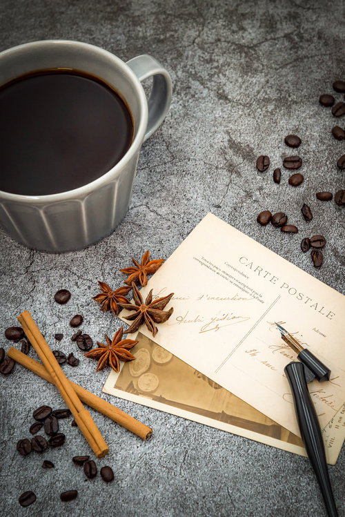 散らばるコーヒー豆とコーヒーカップ、手紙と絵葉書