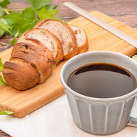 木製まな板にカッティングされたパンとコーヒーカップの写真