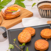 木製まな板に並ぶフルーツデニッシュとガレットブルトンヌの朝食の写真