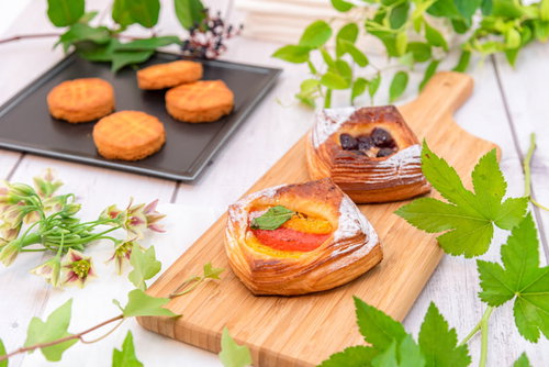 緑で飾られたフルーツデニッシュとガレットブルトンヌの朝食