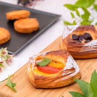 緑の葉で飾られたフルーツデニッシュとガレットブルトンヌの写真