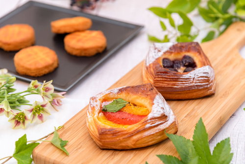 緑の葉で飾られたフルーツデニッシュとガレットブルトンヌ