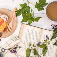 植物で彩るフルーツデニッシュと洋書のティータイムの写真