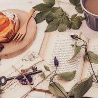 色褪せたフルーツデニッシュと絵はがきのティータイムシーンの写真