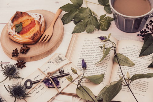 色褪せたフルーツデニッシュと絵はがきのティータイムシーン