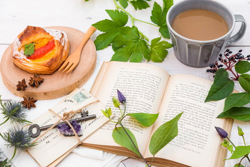 洋書に添えた緑のグリーンと一緒に楽しむフルーツデニッシュとコーヒー