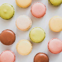 白い背景に並ぶカラフルな洋菓子のマカロンの写真