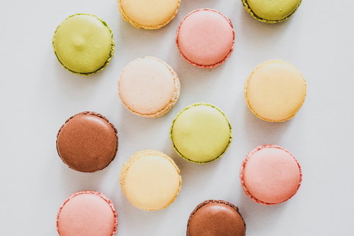 白い背景に並ぶカラフルな洋菓子のマカロン
