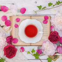 白いテーブルに散らばる薔薇の花びらとローズティーの写真