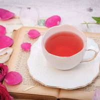 古書に置かれたローズティーと花びらの写真