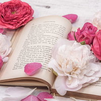 ピンクの薔薇で飾られた読みかけの古書と洋書の写真