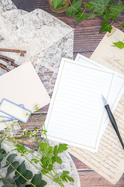 白い便箋に向かう万年筆とデスクの情景、観葉植物のあるオフィス