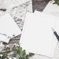 デスクに置かれた便箋と英文の手紙、アンティークキーとペンの写真