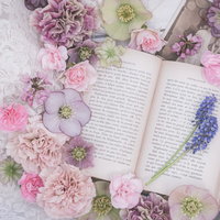 カラフルな生花と洋書のフラットレイの写真