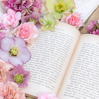 開かれた洋書に添える生花のアレンジメントの写真