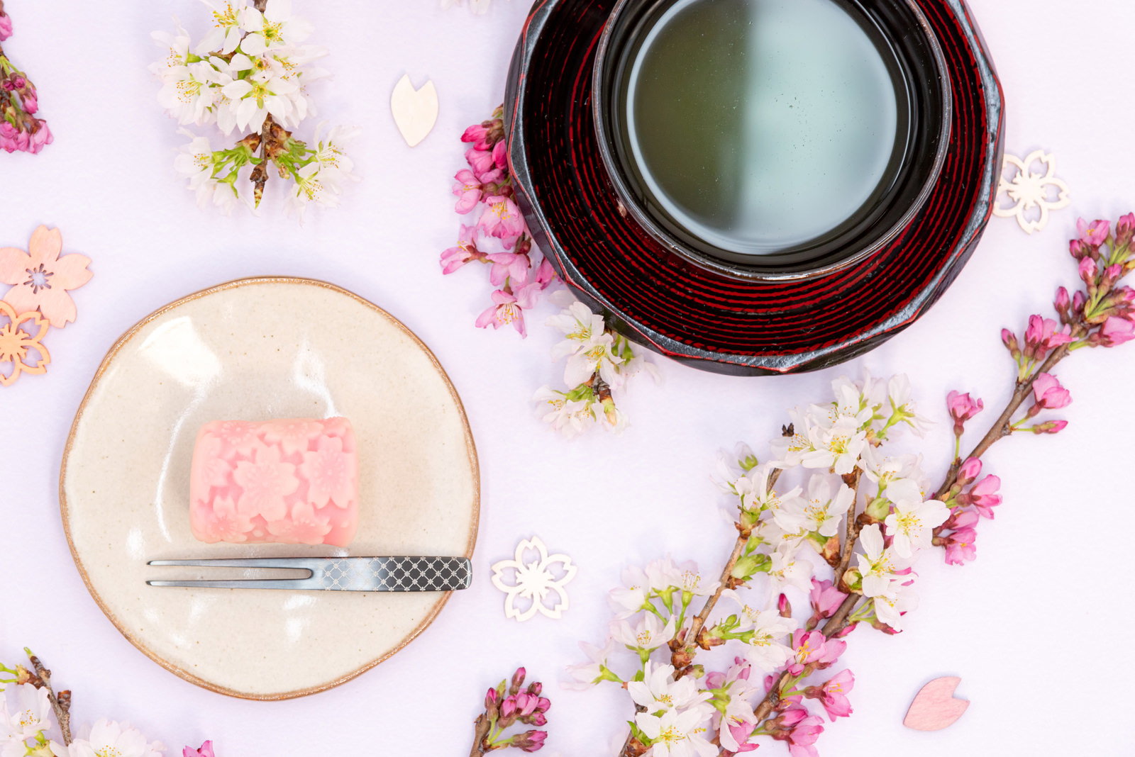 桜の花をかたどった淡いピンクの練り切りと抹茶茶碗