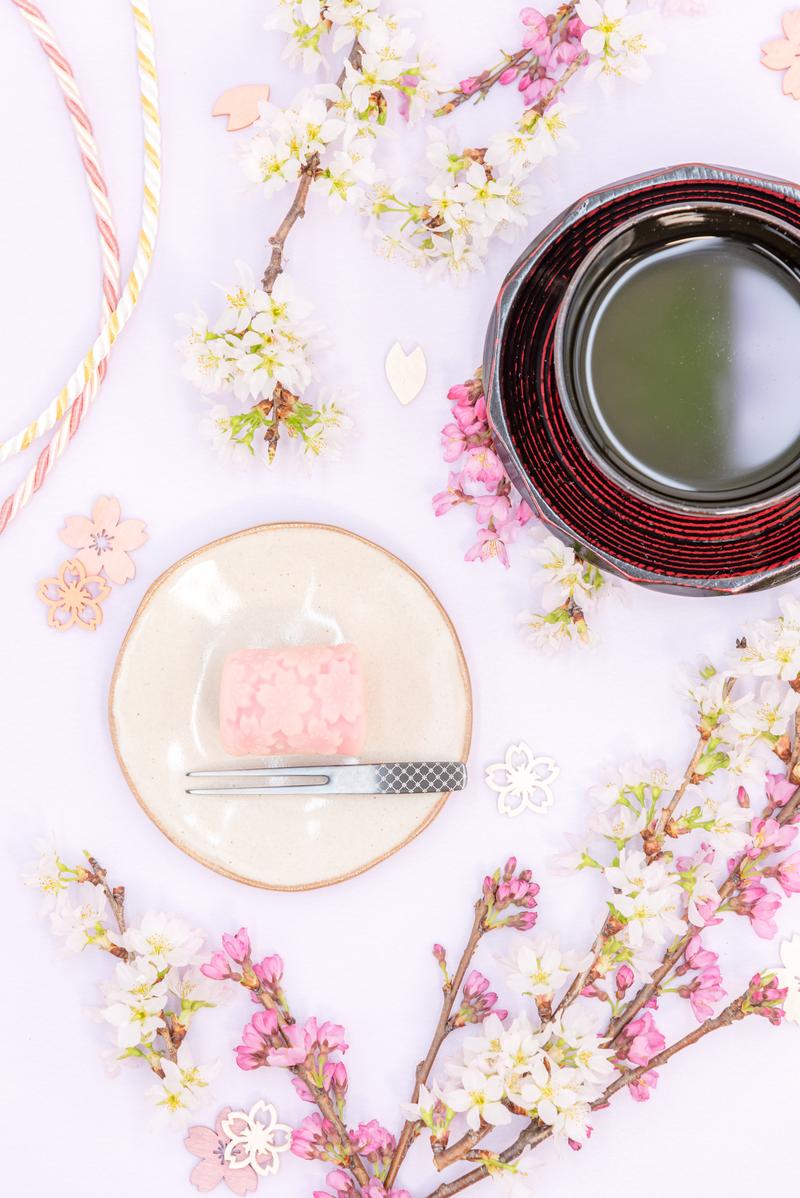 ピンク色の練り切りと抹茶のセット、桜の枝と和の器で春の和菓子をコーディネート
