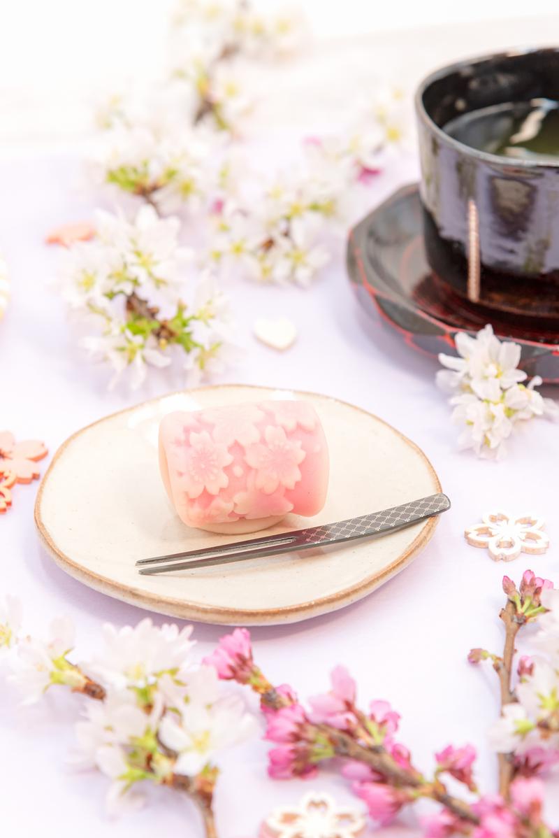 春の花を模った淡いピンク色の練り切りと抹茶の写真