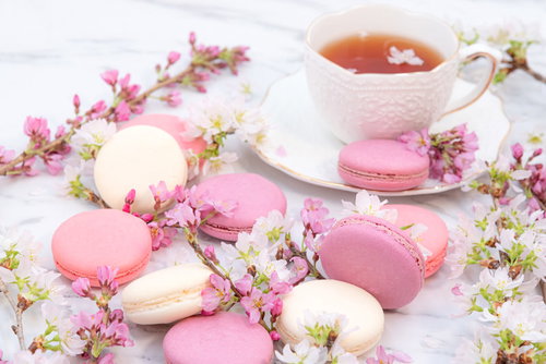 桜の花とマカロンが並ぶティータイムの紅茶