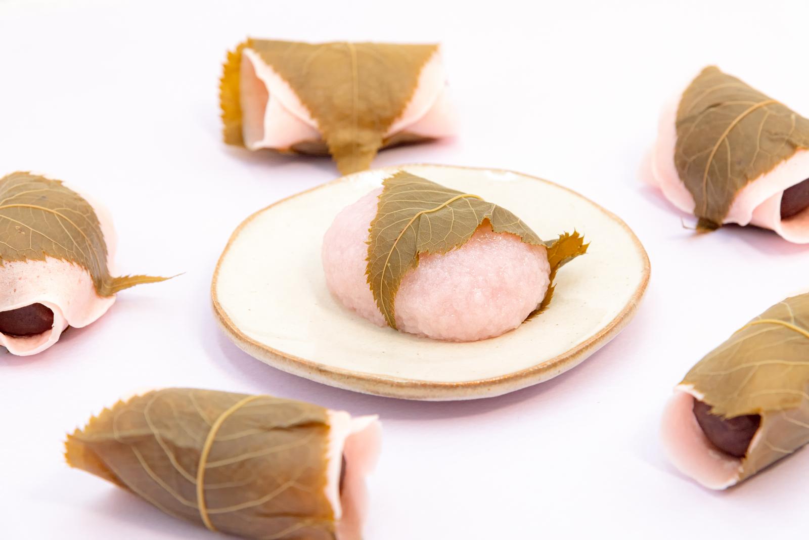 関東風と関西風の桜餅を白い器に盛り付けた写真。春の和菓子が複数並んでいる。