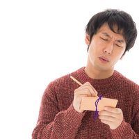 今年も絵馬に祈願する苦学生男性の真剣な表情の写真