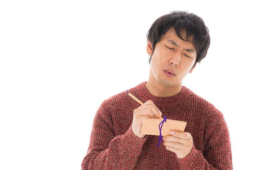 今年も絵馬に祈願する苦学生男性の真剣な表情