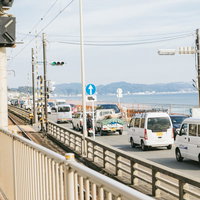 鎌倉高校前駅の踏切で渋滞する海岸沿いの道路の写真