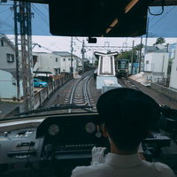 江ノ電の先頭車両から見た線路と運転士の視点の写真