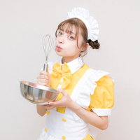 黄色のメイド服でホイッパーを持ったコスプレ女性の写真