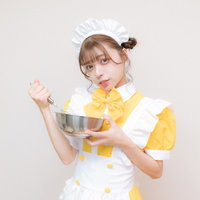 メイド服とエプロン姿で料理をする女性のコスプレの写真