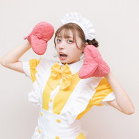 ピンクの鍋つかみを手にして驚くメイド服の女性の写真