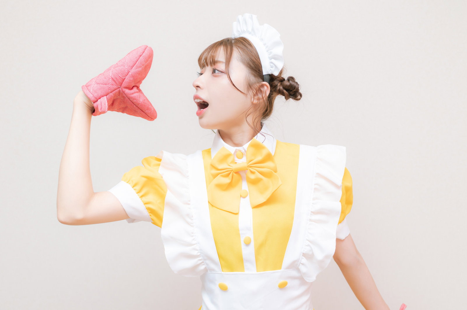 ピンク色のミトンを手に持ち会話するようなポーズのメイド服女性［モデル：高尾実生］