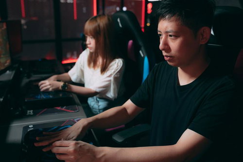 真剣な眼差しでゲームに没頭するカップル、ヘッドセット装着で対戦中