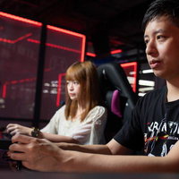 赤いネオンが光るeスポーツ施設でトレーニング中のプロゲーマーの写真