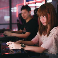 ゲームセンターでeスポーツデートを楽しむカップルの写真