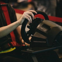 eスポーツのレースゲームでハンドルコントローラーを握って操作する手の写真