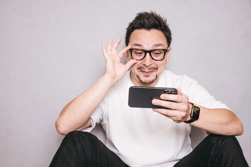 スマホを見てニヤケる眼鏡をかけたドイツ人ハーフ男性